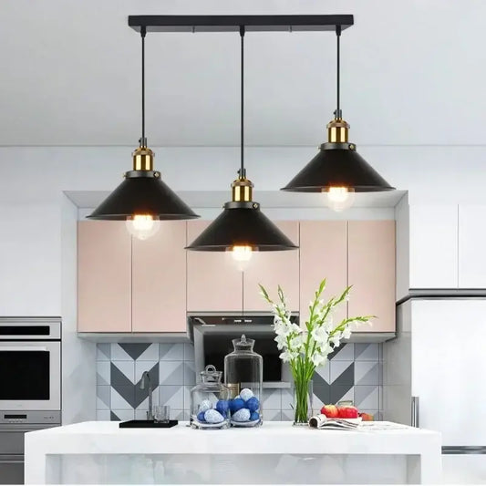 Vintage black metal pendant light with brass accents and metal finish hanging above kitchen island