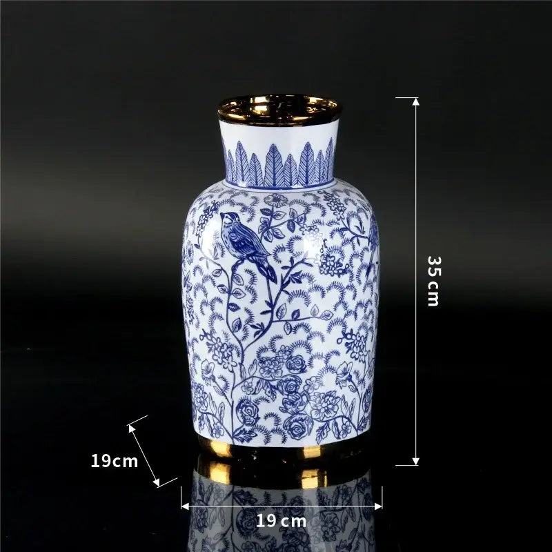 A white porcelain ceramic vase with blue floral bird patterns and gold rims ideal for home decor