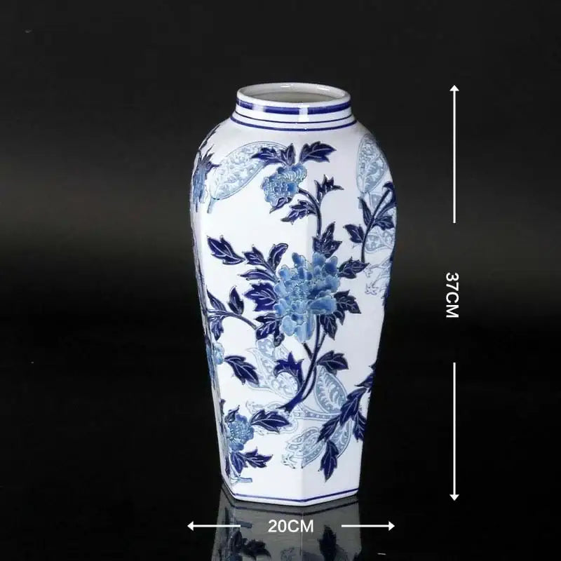 A tall white porcelain ceramic vase with blue floral patterns and hexagonal base for home decor