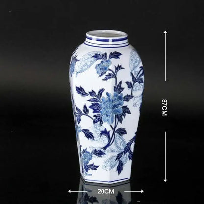 A tall white porcelain ceramic vase with blue floral patterns and hexagonal base for home decor