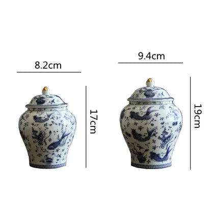 Two blue and white porcelain general jars with intricate fish and flower designs and gold tipped lids for decorbites blue living room storage