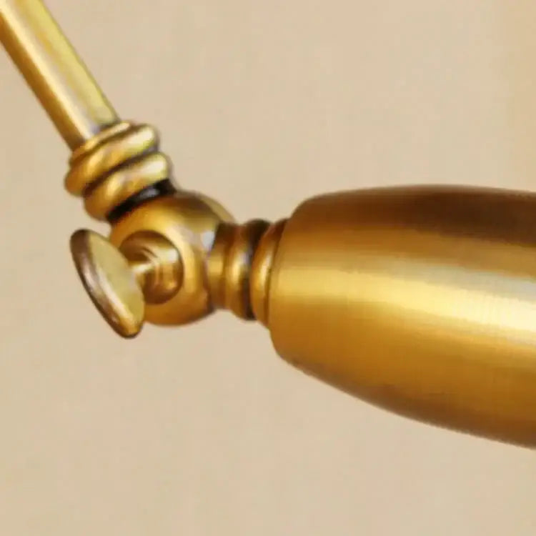Brass-finished vintage wall light with adjustable long arm and polished cylindrical design for bedroom decorbites decor