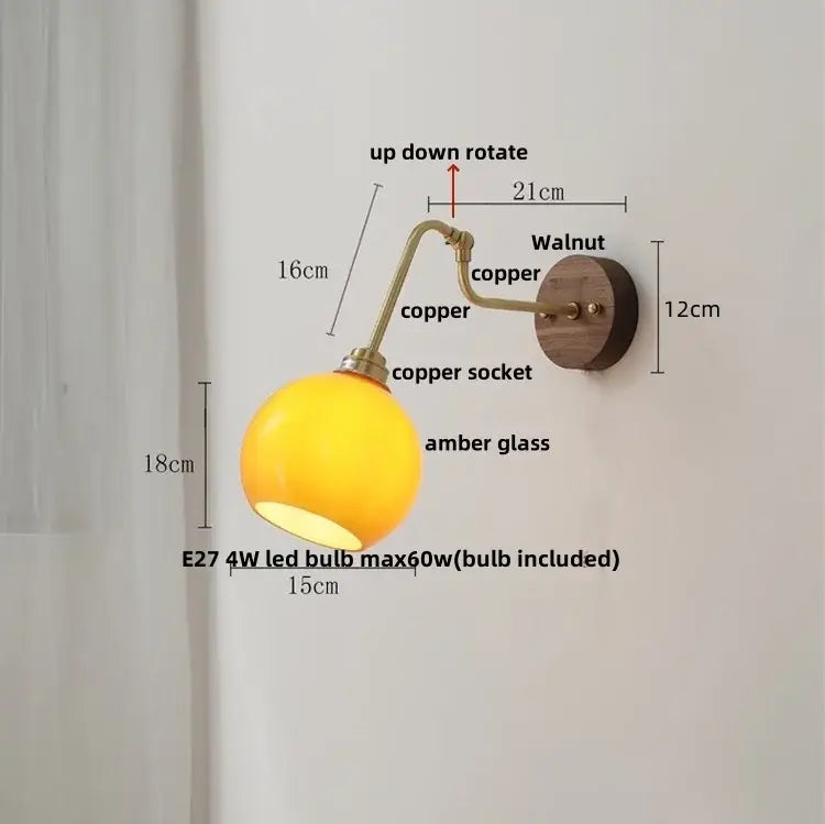 Copper-finished decorbites led wall sconce with spherical amber glass shade and walnut wood backplate for bedroom lighting