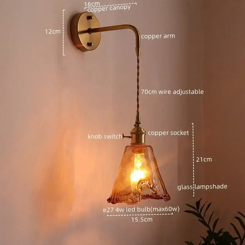 Copper led wall sconce with twisted wire arm, brass canopy, and amber glass copper led lampshade for bedroom lighting
