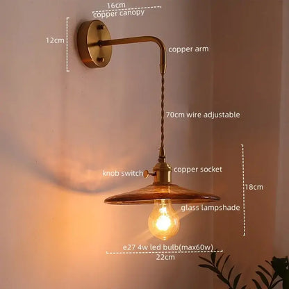 Vintage brass and amber glass copper led wall sconce featuring a glass lampshade and exposed LED bulb for bedroom lighting
