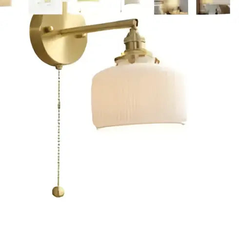 Brass-finished led wall lamp with amber glass, pleated off-white shade, and pull chain for bedroom sconce lighting