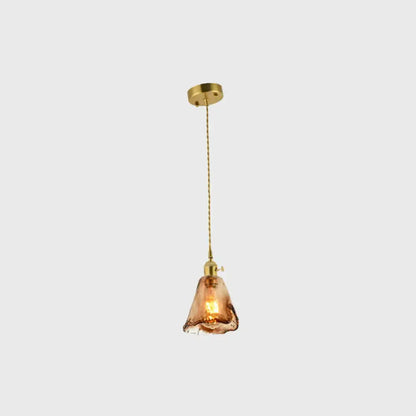 A warm amber glass pendant light with brass shaded drop and ceiling mount for living room decor by decorbites
