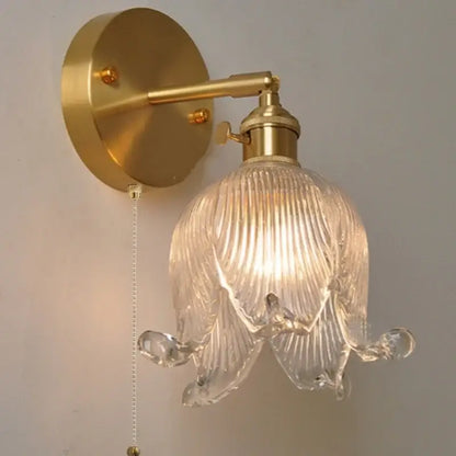 Gold-toned vintage brass wall light with clear ribbed loft amber glass shade shaped like an open flower for bedroom decorbites loft amber