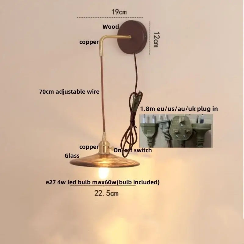 Vintage brass and amber glass wall sconce with warm-toned brass pendant lamp and pull chain switch for stair lighting