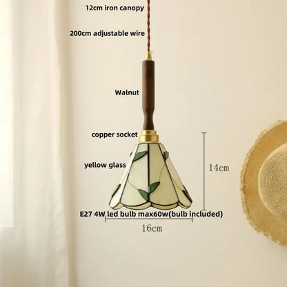 A 14cm vintage brass and decorbites ceramic walnut wood pendant light with yellow glass and green leaf stained shade