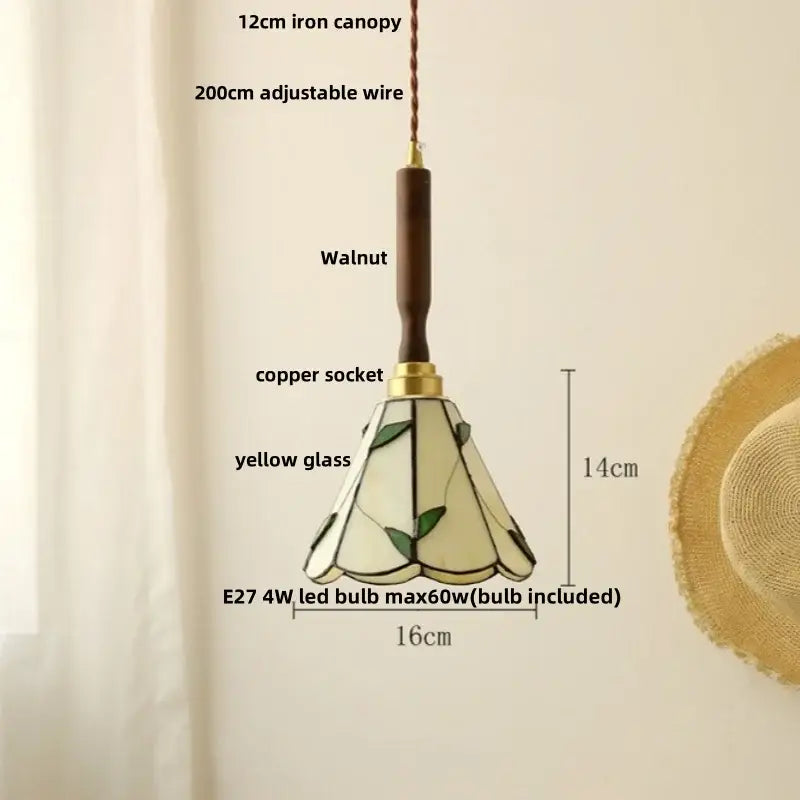 A 14cm vintage brass and decorbites ceramic walnut wood pendant light with yellow glass and green leaf stained shade