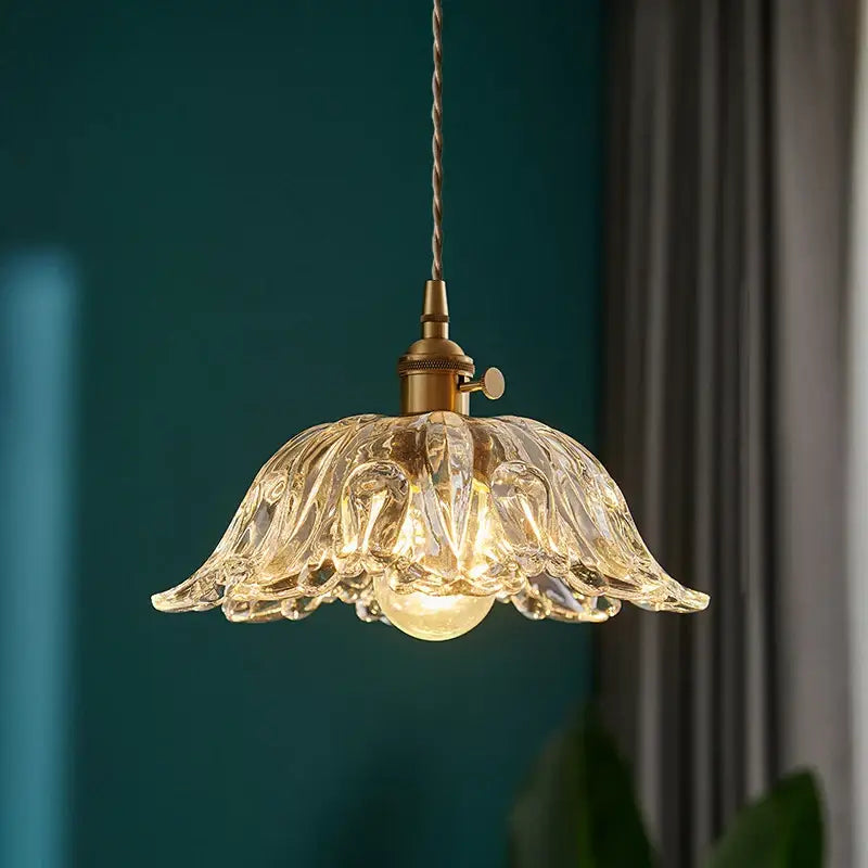 Vintage brass and clear glass pendant light with a delicate fluted floral shade and polished copper hardware for kitchen use