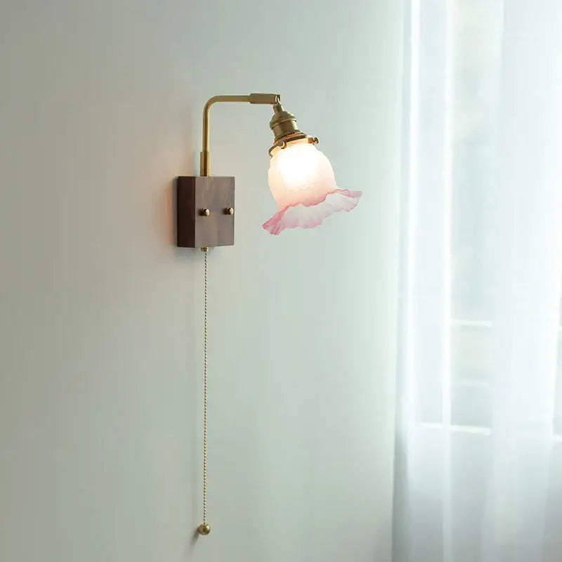 Vintage brass and glass pink led wall lamp with delicate ruffled glass shade and dark wood base for bedroom sconce