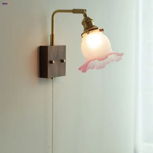 Vintage brass wall lamp with a glass pink led shade featuring ruffled edges for bedroom sconce lighting