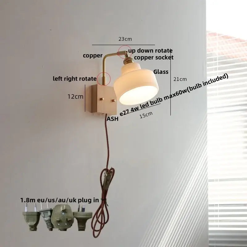 A warm-toned vintage brass wall lamp with a copper arm and off-white glass pink led shade for bedroom use