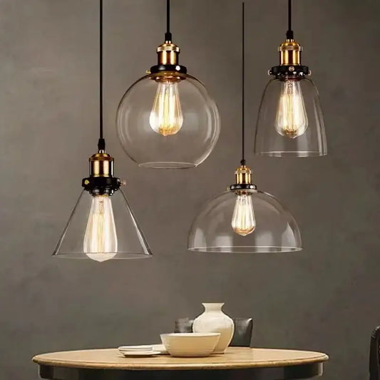 Set of four vintage brass pendant lights with gray glass shades and exposed Edison bulbs for kitchen use