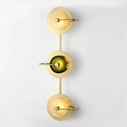 Vintage brass wall lamp with green glass central element and three stacked circular shades as metal wall art light