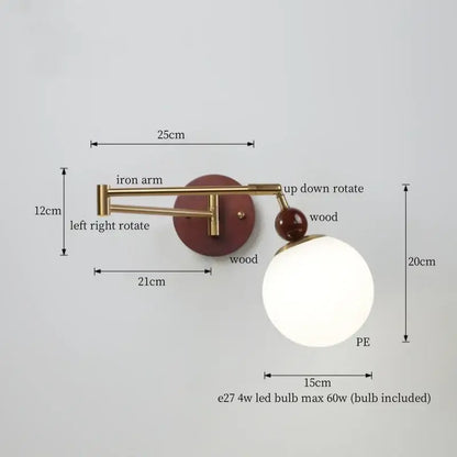 A modern adjustable wall lamp with brass iron arm, reddish-brown wooden base, and creamy iron led spherical shade by decorbites