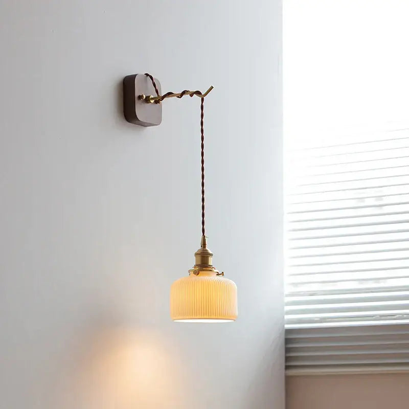 Vintage brass and ribbed glass led wall sconce with warm tones and twisted cord decorbites led wall lighting