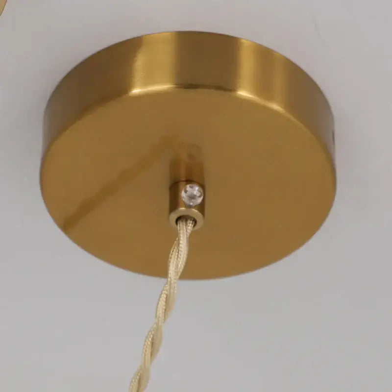 Vintage brass pendant light with gold circular fixture, beige twisted cord, crystal accent, and white shade for dining room