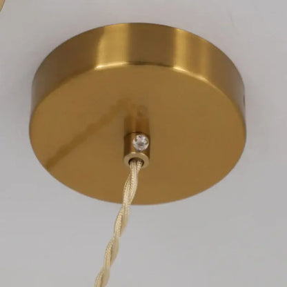Vintage brass pendant light with gold circular fixture, beige twisted cord, crystal accent, and white shade for dining room