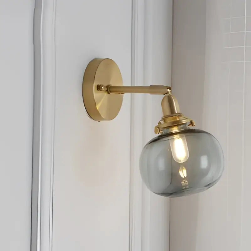 Gold-toned vintage brass led wall lamp with clear smoky glass spherical shade for bedroom sconce lighting
