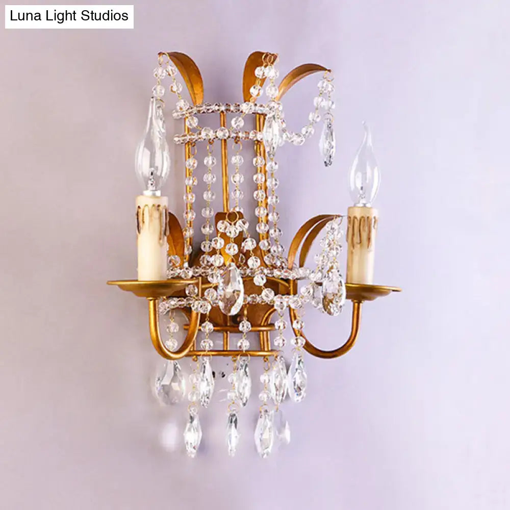 Gold-toned vintage brass direct wired wall lamp with clear crystal beads and teardrop pendants for bedroom chandelier use