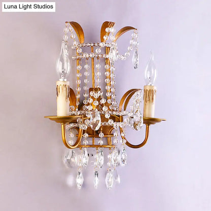 Gold-toned vintage brass direct wired wall lamp with clear crystal beads and teardrop pendants for bedroom chandelier use