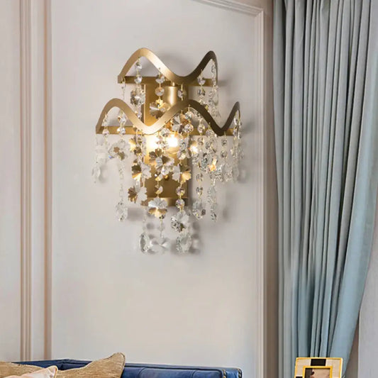 Vintage brass crystal wall sconce with gold-toned wavy frame direct wired bulb base and clear crystal leaf accents