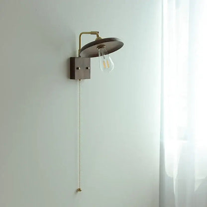 Vintage brass and dark wood wall light sconce with matte bronze circular shade and exposed Edison bulb decorbites copper