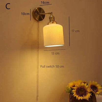 Brass-finished decorbites ceramic sconce lamp with ribbed off-white glass shade and pull chain for bedroom reading light