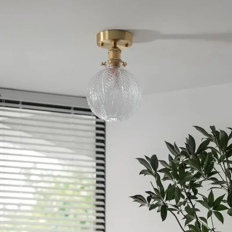Vintage brass etched glass led ceiling light featuring a clear intricately etched glass globe and brass ceiling mount