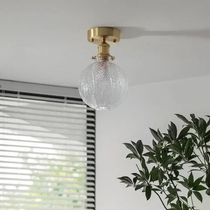 Vintage brass etched glass led ceiling light featuring a clear intricately etched glass globe and brass ceiling mount