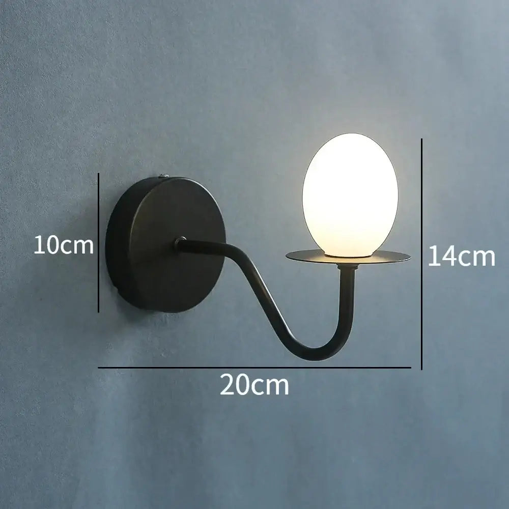 Black metal wall lamp with a glass egg mini frosted bulb designed as an egg mini wall sconce for bedroom use
