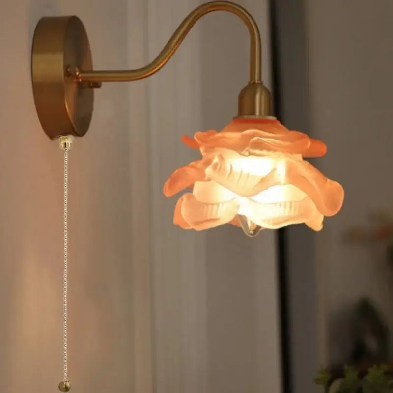A warm-toned vintage brass led wall light with a rose-shaped fluted glass shade and pull chain for bedroom decorbites brass led