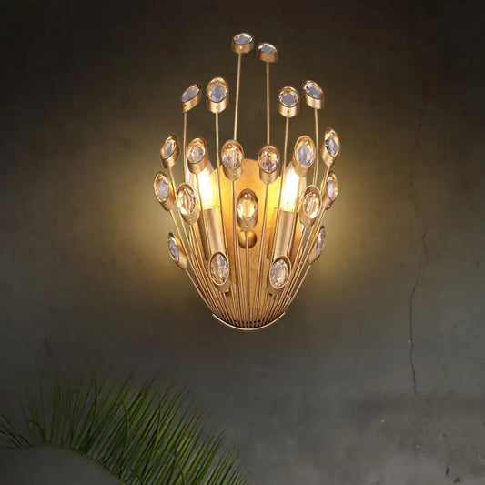 Vintage brass peacock tail design wall sconce with gold tone, clear crystal accents, and warm glowing bulbs for bedroom