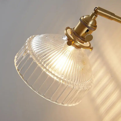 Vintage brass wall lamp with clear ribbed glass pull chain and brass-finished metal arm for living room lighting