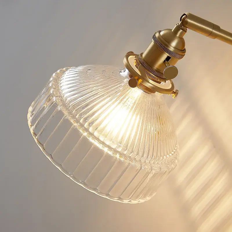 Vintage brass wall lamp with clear ribbed glass pull chain and brass-finished metal arm for living room lighting