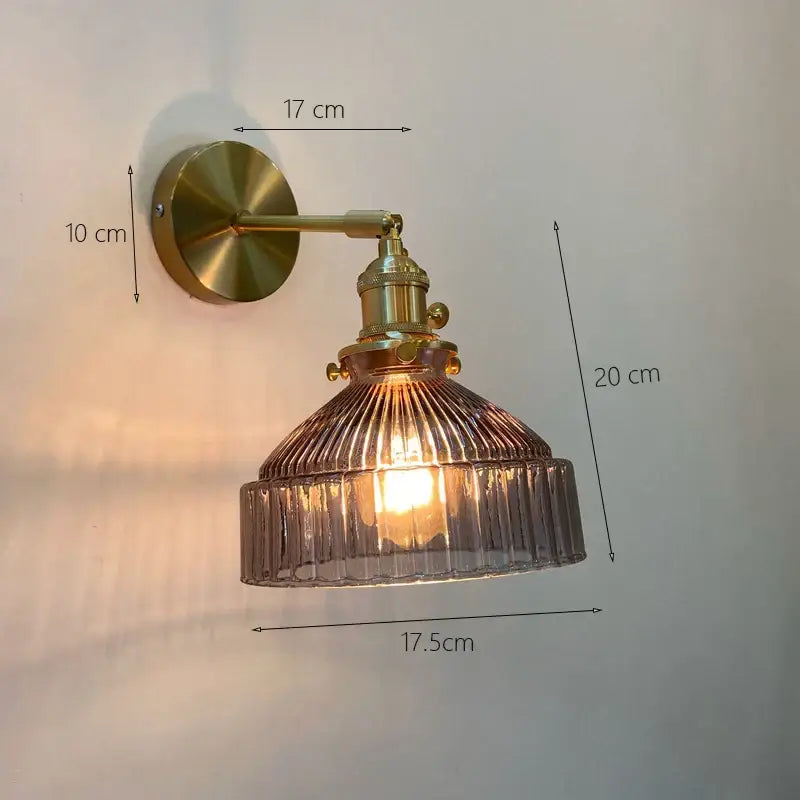 Vintage brass wall sconce featuring a ribbed smoked glass shade designed as a stylish bedroom wall lamp