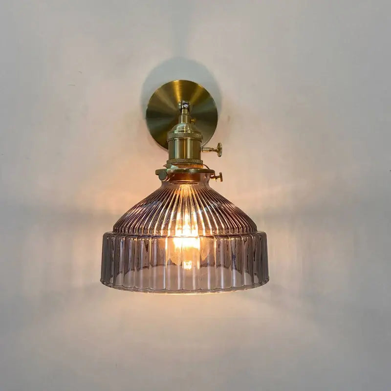 Vintage brass ribbed glass shade wall sconce with warm-toned glass shade and brass-finished wall lamp fixture