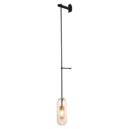 Black metal wall-mounted brass wall lamp with clear glass cylinder shade housing an illuminated bulb for living room use
