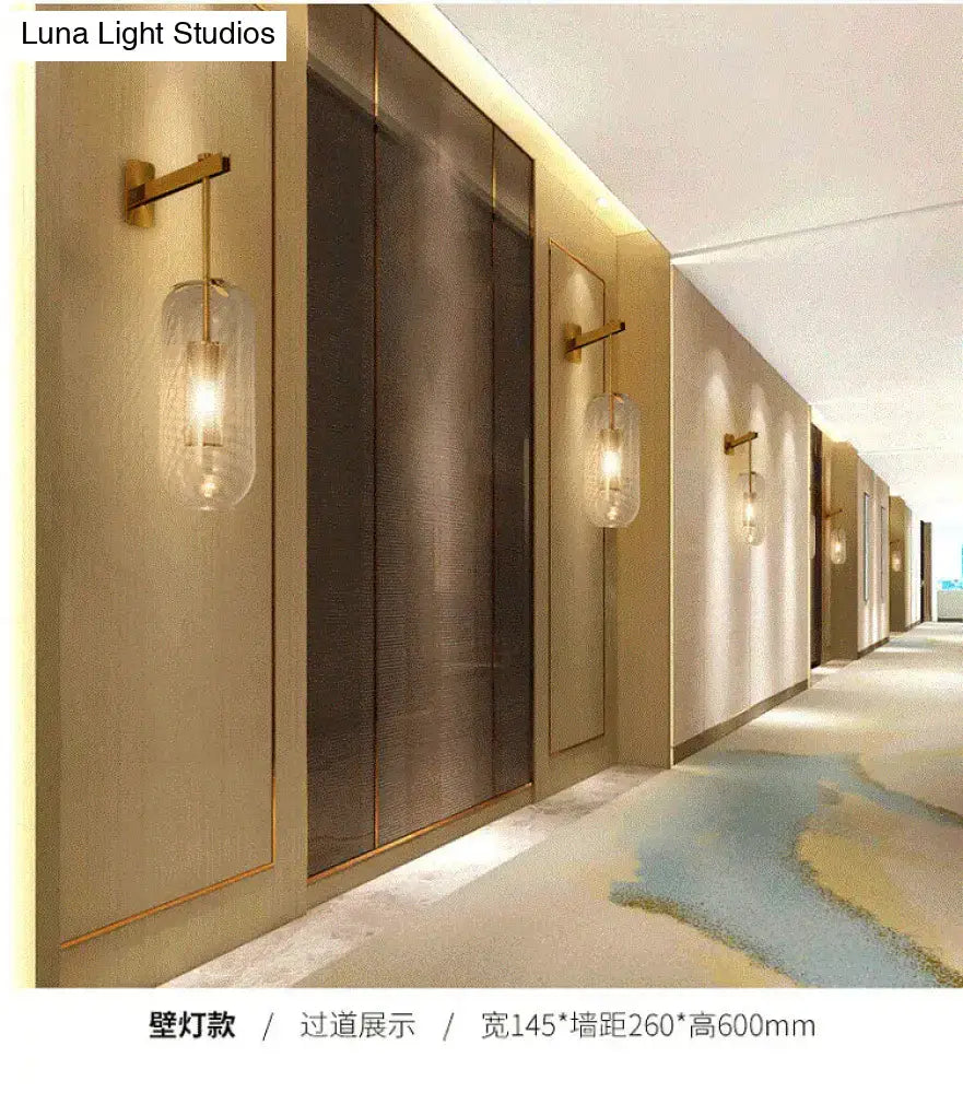 Gold-toned brass wall lamp with a clear glass cylinder shade for living room vintage style wall sconce lighting