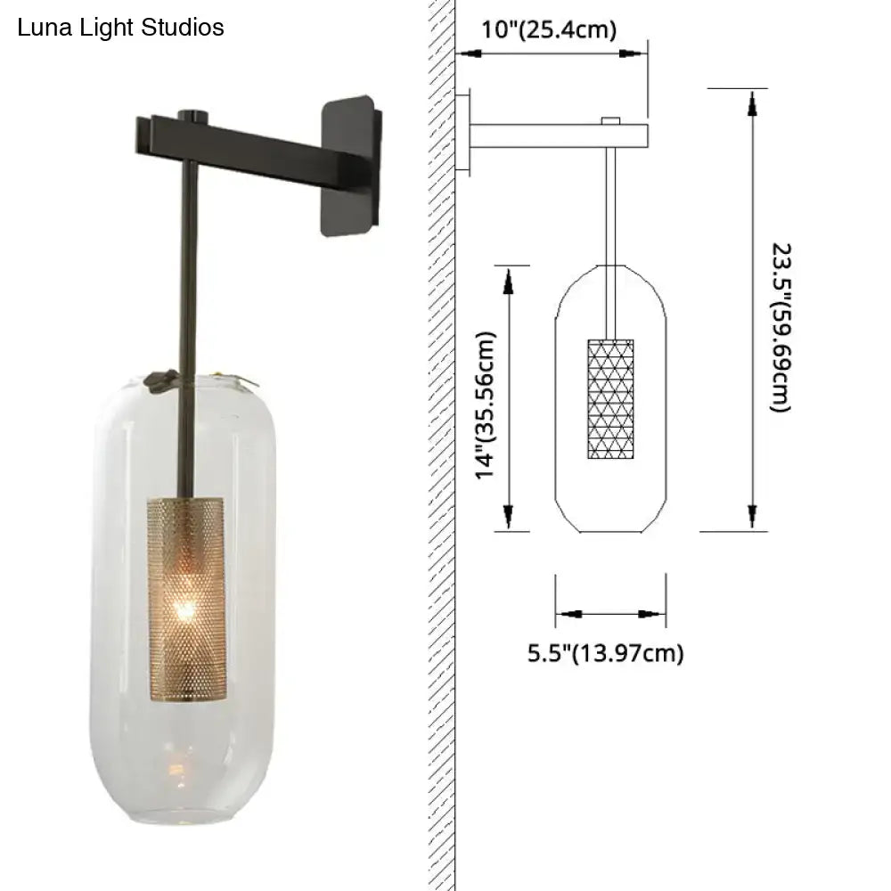 Black metal wall sconce with a brass wall lamp featuring a clear glass cylinder and gold-toned mesh glass cylinder shade