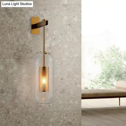 A vintage brass wall lamp with a clear glass cylinder shade and illuminated glass cylinder for living room use
