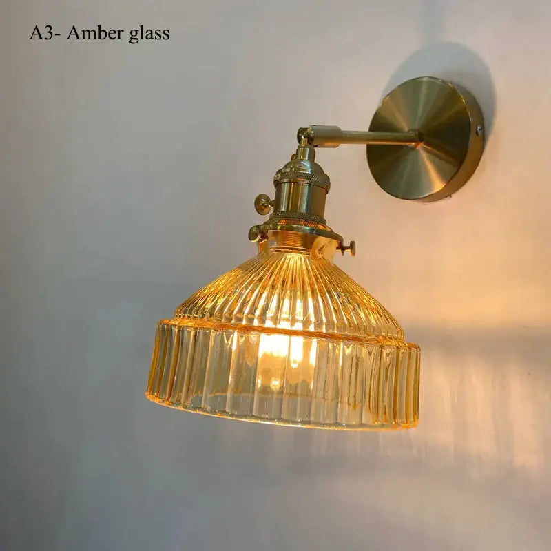 Vintage brass wall lamp with amber ribbed glass shade and brass-finished metal hardware for living room use