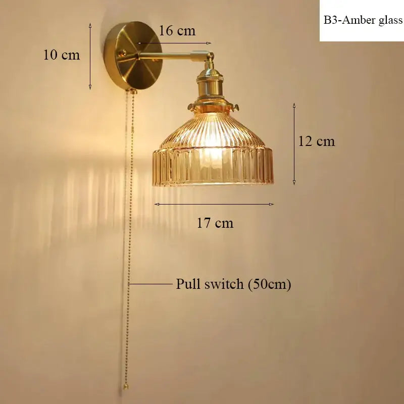Vintage brass wall lamp with ribbed amber glass shade and pull chain switch for living room use