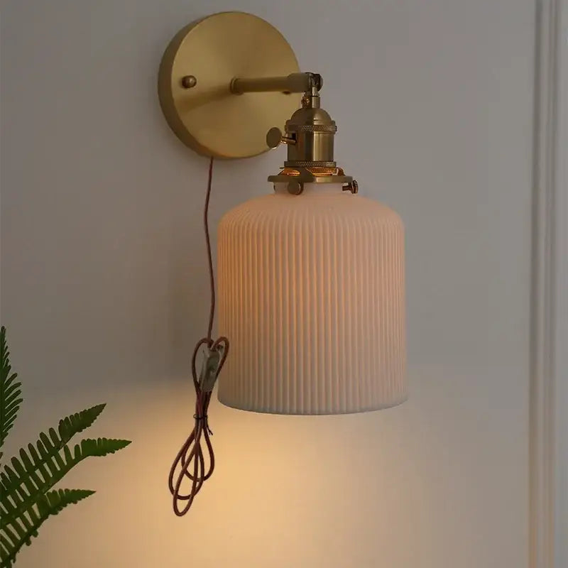Vintage brass wall light with ribbed off-white glass shade and knob switch featuring decorbites ceramic knob and exposed wiring