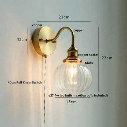 Vintage brass wall sconce with scalloped clear glass and copper ribbed globe featuring decorbites clear glass pull chain switch
