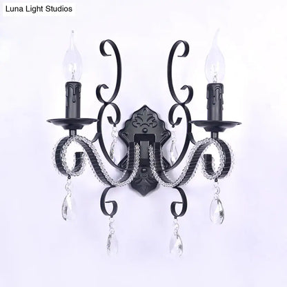 Black wrought iron wall mounted lamp with crystal accents and two candle-style bulbs for vintage living room decor