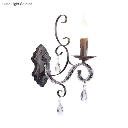 Elegant black wrought iron wall mounted lamp with crystal teardrop pendants and candle-style bulb for living room use